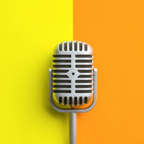Flat lay of retro microphone on double colorful background.